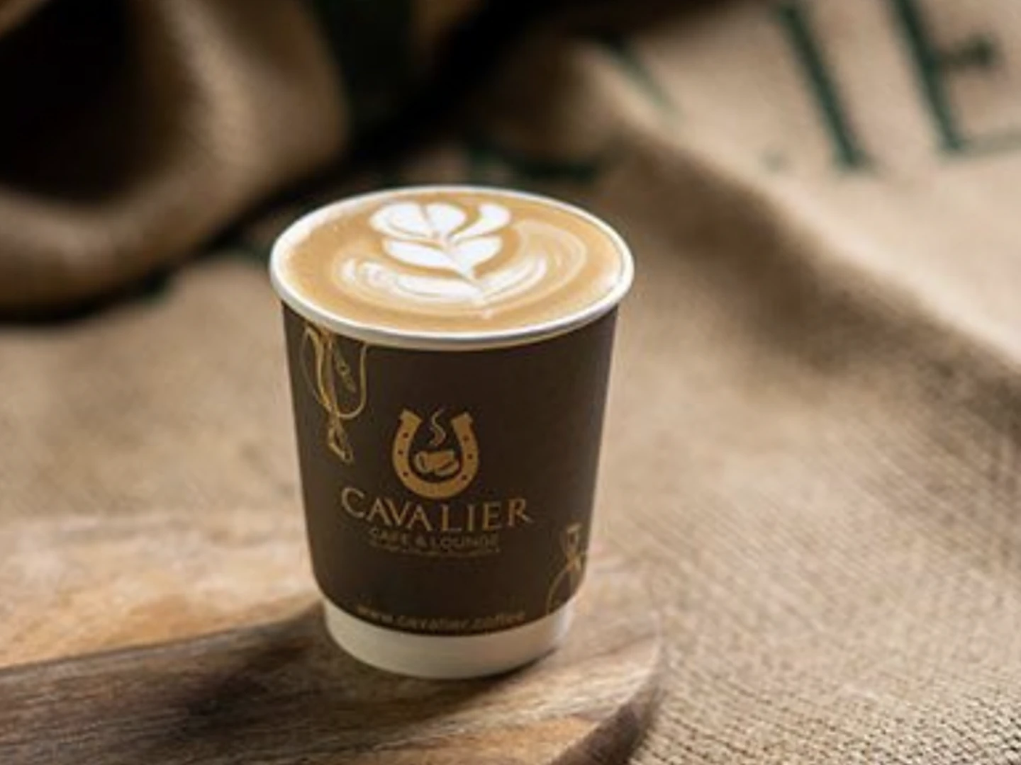 Cavalier Cafe latte with rosette latte art in a Cavalier-branded cup, Doha cafe